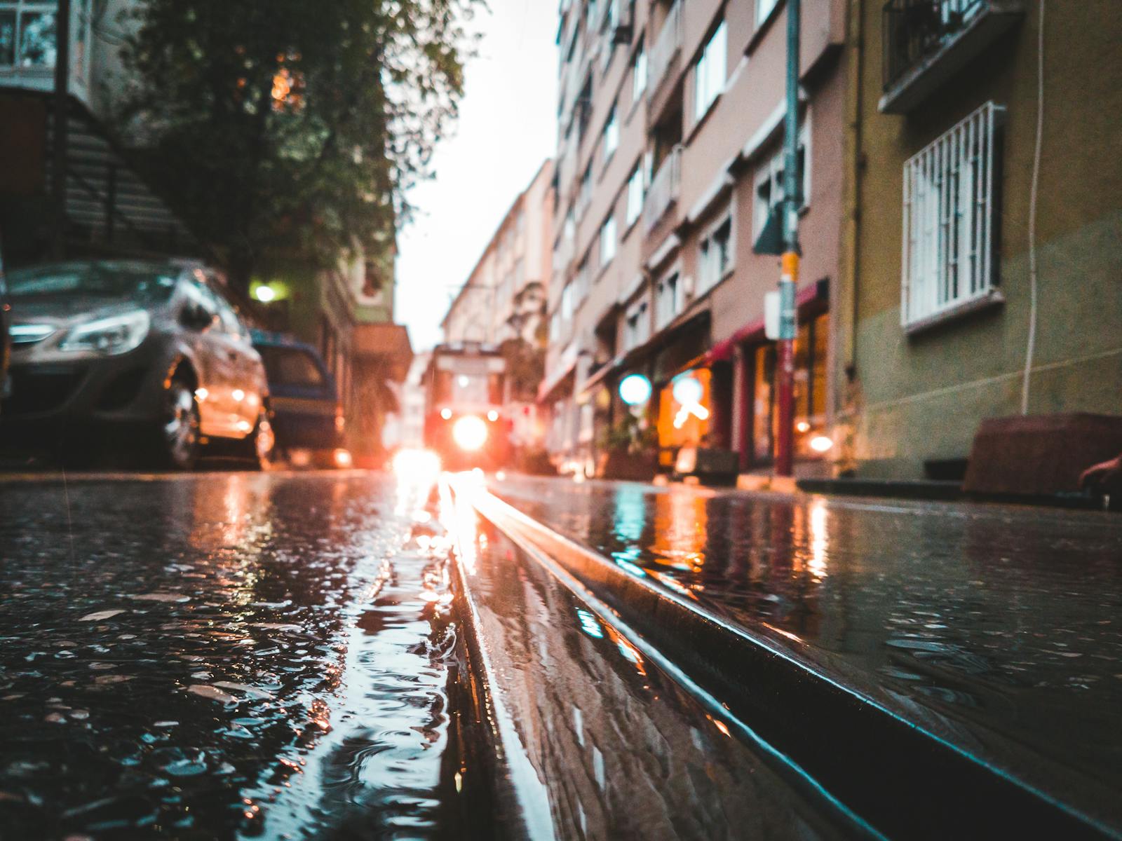 Flood, Moody street scene in Istanbul with a tram reflecting in rain-soaked pavement.